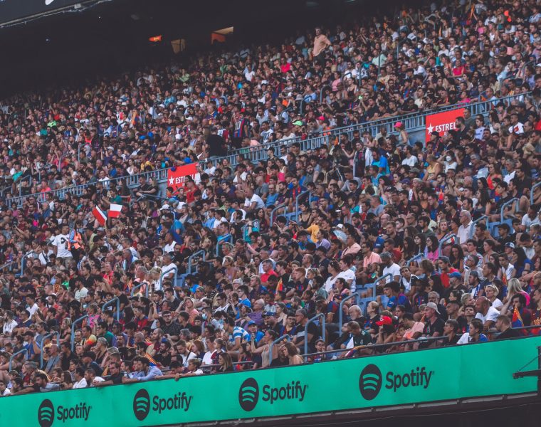 A packed stadium with enthusiastic fans cheering, showcasing diverse spectators.